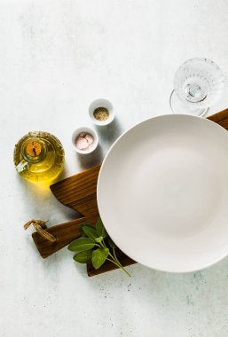 Tablo ayarı. iki boş tabak, baharat, çatal bıçak takımı ve zeytin yağı. metin yazmak için bir yer. kopya alanı. kolaj şablonu
