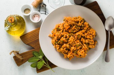 İtalyan risotto ile domates sosu ve yeşil bezelye, ahşap kesme tahtası bir tabakta servis. klasik Akdeniz mutfağı. Tüm aile için sağlıklı vegan yemek