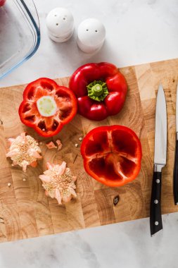 biber temizlik. doldurma için hazırlık. bir kesme tahtası ve bir bıçak. beyaz mermer masanın üstünde. cam yemek pişirme