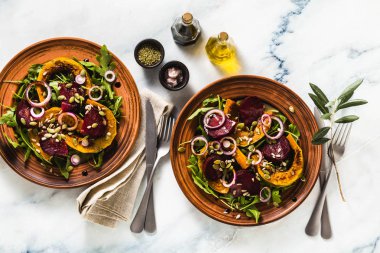 sıcak salata Fırında kabak ve pancar roka ve tohum mermer bir tablo ile. Tüm aile için sağlıklı vejetaryen mutfağı