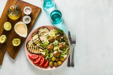 iştah açıcı bir akşam yemeği ya da öğle yemeğinden bir salata domates, patlıcan ve baklagil falafel Susam tahin sos ile ızgara. Tüm aile için sağlıklı gıda vejetaryen