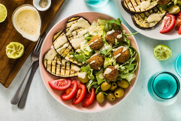 iştah açıcı bir akşam yemeği ya da öğle yemeğinden bir salata domates, patlıcan ve baklagil falafel Susam tahin sos ile ızgara. Tüm aile için sağlıklı gıda vejetaryen