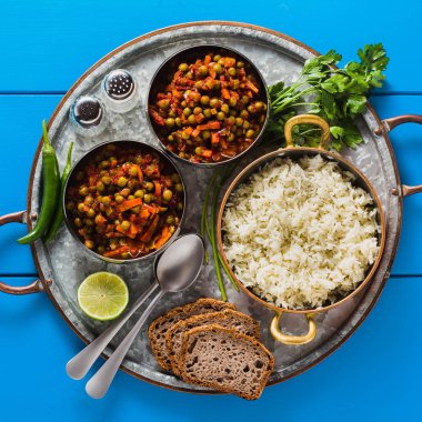 bir mavi tablo tepsi, sağlıklı Hint konfor yiyecek Vegan köri yeşil bezelye ve basmati pilav ile servis