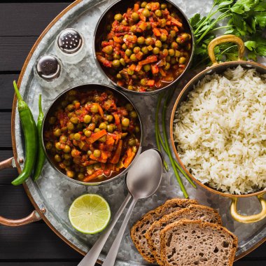 bir ahşap masa tepsi, sağlıklı Hint konfor yiyecek Vegan köri yeşil bezelye ve basmati pilav ile servis