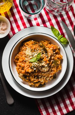 Masanın üzerine domates soslu İtalyan risotto.