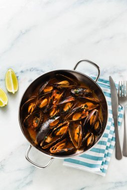 taze pişmiş bir tavada domates soslu midye. pepata di cozze veya midye marinara. beyaz ile mavi mermer masa üzerine Akdeniz İtalyan mutfağının klasik çanak
