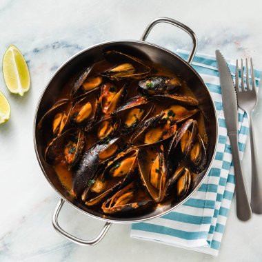 taze pişmiş bir tavada domates soslu midye. pepata di cozze veya midye marinara. beyaz ile mavi mermer masa üzerine Akdeniz İtalyan mutfağının klasik çanak