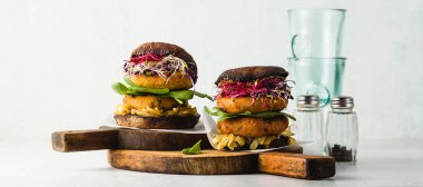 afiş glutensiz vejetaryen burger portobello mantar patates pirzola ile yapılan ve karamelize soğan, Brüksel lahanası ve bebek ıspanak ile nohut un. Sağlıklı doğal ürünler yapılan lokanta