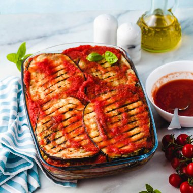 Vegan patlıcan Parmigiana bezelye ve mercimek ve domates Mermer mutfak masası üzerinde yapılmış. Tüm aile için sağlıklı konfor tarifi