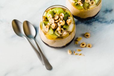 Vegan muz tatlı yeşil buğday, chia tohum ve bir bardak taze meyve, fındık ve bal ile yaban mersini reçeli ile quinoa, katmanlı. sağlıklı sabah yemek kahvaltı.