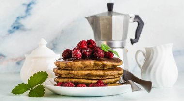 gluten free yeşil buğday bayrağı taze meyveleri ve akçaağaç şurubu ile krep. Yumurta, un ve rafine şeker olmadan lezzetli vejetaryen kahvaltı. Bütün aile için sağlıklı yemek. Moka pot sabah kahve ile
