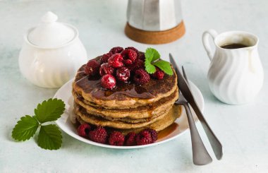 taze meyveleri ve akçaağaç şurubu ile Gluten-Alerjik yeşil karabuğday krep. Yumurta, un ve rafine şeker olmadan lezzetli vejetaryen kahvaltı. Bütün aile için sağlıklı yemek. Moka pot sabah kahve ile
