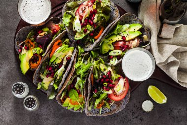 Gluten free vegan tacos tahin sosu ve nar tohumları ile domates ve avokado salatası ile siyah fasulye dan. Tüm aile veya karanlık bir arka plan bira ile parti için sağlıklı lokanta