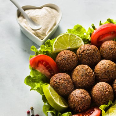 Vegan falafel doğranmış domates ve limon dilimleri ile bir tabloda kaju peynir soslu. Tüm aile veya parti için sağlıklı gıda