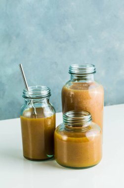 farklı gözlük ile taze greyfurt, kivi, Trabzon hurması ve ahududu smoothies yaptı. beyaz masa ve mavi arka plan. sağlıklı gıda. sabah kahvaltı