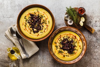 Otantik Yunan Fava tarifi, karamelize soğan, kırmızı biber ve kapari ile Orta Doğu sarı mercimek çorbası. kil tencere taş masanın üzerine Vegan sağlıklı gıda