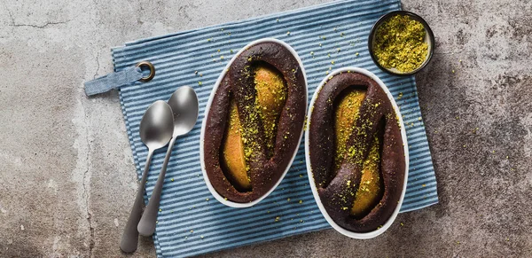 banner of chocolate cake pudding with pear and pistachios without flour. gluten free. on the table . holiday dessert