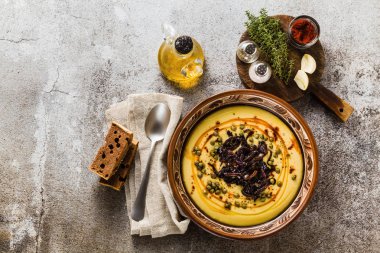 Otantik Yunan Fava tarifi, karamelize soğan, kırmızı biber ve kapari ile Orta Doğu sarı mercimek çorbası. kil tencere taş masanın üzerine Vegan sağlıklı gıda