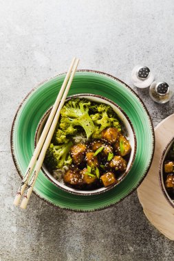 General Tso sos ve haşlanmış brokoli tofu ile basmati pirinç. tam sağlıklı vejetaryen öğle veya akşam yemeği taş bir tablo