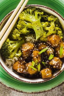 General Tso sos ve haşlanmış brokoli tofu ile basmati pirinç. tam sağlıklı vejetaryen öğle veya akşam yemeği taş bir tablo