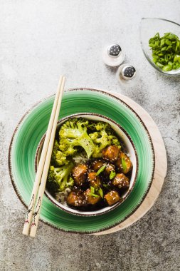 General Tso sos ve haşlanmış brokoli tofu ile basmati pirinç. tam sağlıklı vejetaryen öğle veya akşam yemeği taş bir tablo