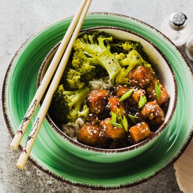 General Tso sos ve haşlanmış brokoli tofu ile basmati pirinç. tam sağlıklı vejetaryen öğle veya akşam yemeği taş bir tablo