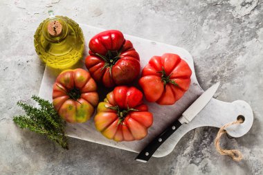 bir kesme tahtası üzerinde Brandywine domates. yemek yaz salata taze zeytinyağı, kekik. taş bir masada