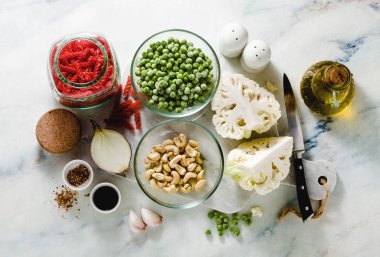 zeytinyağı ve baharat mermer masada karnabahar ve yeşil bezelye ile gluten-Alerjik kırmızı mercimek makarna için taze malzemeler. sağlıklı vejetaryen mutfağı