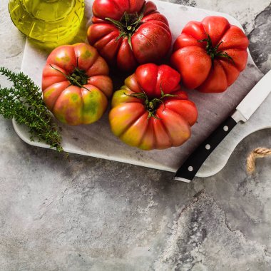 bir kesme tahtası üzerinde Brandywine domates. yemek yaz salata taze zeytinyağı, kekik. taş bir masada