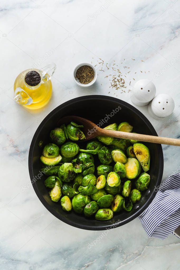 Brussels sprouts fried in a non-stick pan. spices and olive oil. cooking healthy winter food