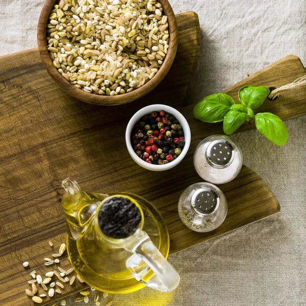 Getreidemischung in einer Holzschüssel auf einem Schneidbrett mit Olivenöl — Stockfoto
