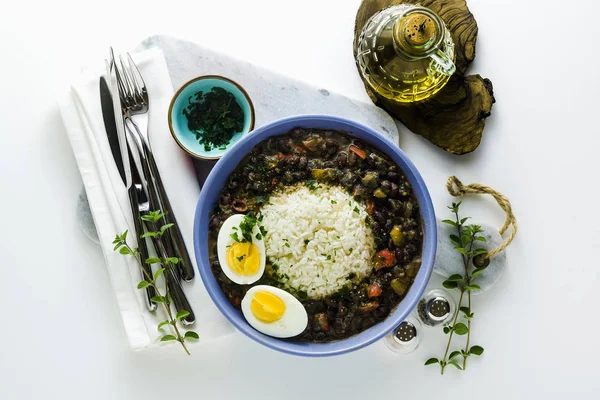 rice with black beans and boiled egg on the table with spices an