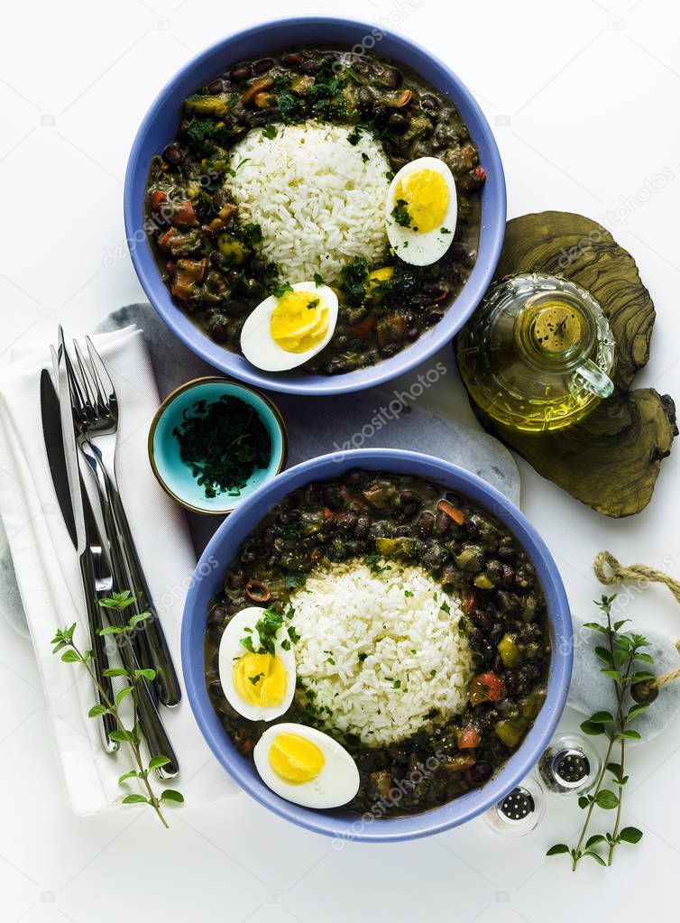 rice with black beans and boiled egg on the table with spices an
