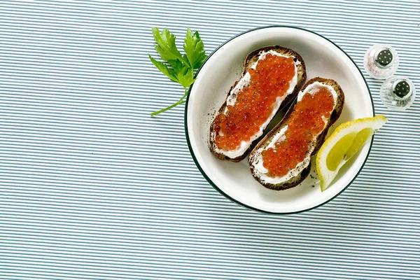 Vers brood sandwich met rode kaviaar en zachte kaas op een bord. — Stockfoto