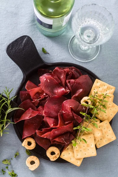 Bresaola italiano servido en rodajas en una bandeja sobre una mesa con w blanco —  Fotos de Stock