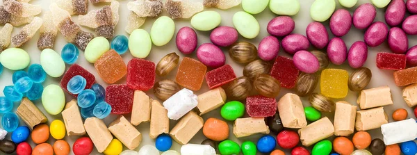 Баннер из разноцветных карамельных конфет, разбросанных по столу ба — стоковое фото