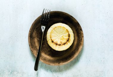 Fırında pişmiş ricotta peynirkil bir tabak ve çatal üzerinde. temel cookin