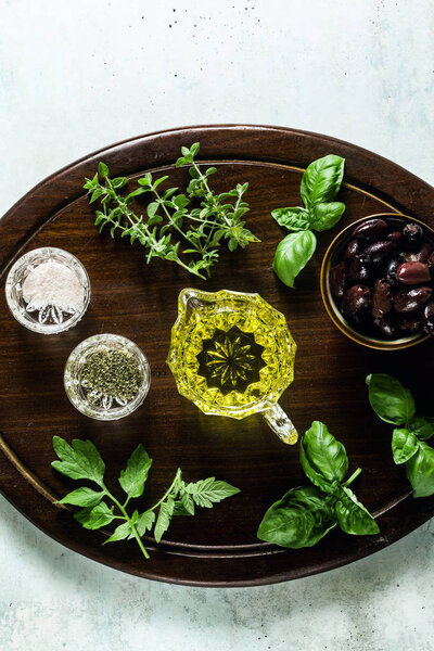 aromatic herbs for cooking and olive oil on a wooden board on th