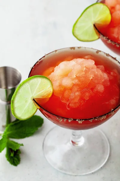 Red Frozen Margarita, refreshing cocktail on the table and lime