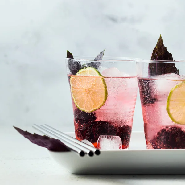 Gin Tonic mit Brombeeren und Blättern von violettem Basilikum. Sommer r — Stockfoto