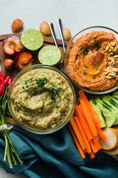 veggie serving table with snacks with vegetables, fruits, baba g