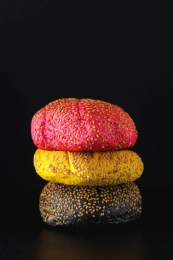 Farklı renklerde büyük hamburgerler. Kırmızı, sarı çörekler. 