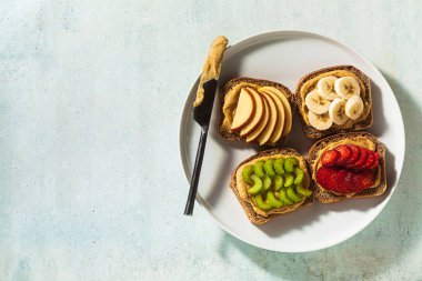 Fıstık ezmeli, çilekli, kerevizli, muzlu ve elmalı çeşitli sandviçler. Mükemmel sabah kahvaltısı