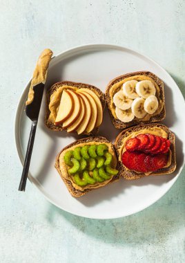 Fıstık ezmeli, çilekli, kerevizli, muzlu ve elmalı çeşitli sandviçler. Mükemmel sabah kahvaltısı