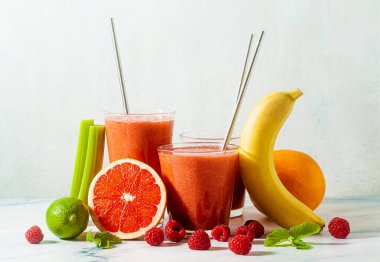 Taze meyve suyu bardaklarda, masada metal tüplerle ve malzemelerle. Sağlıklı yiyecekler