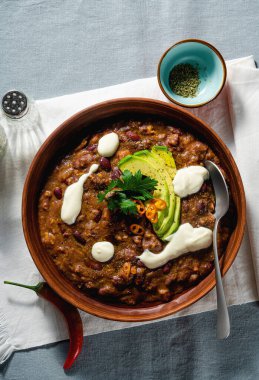 Etsiz vejetaryen acı biber çorbası, pinto fasulyesi ve avokado, soyadan yapılan yoğurtla servis edilen keten masa örtüleri. sağlıklı beslenme
