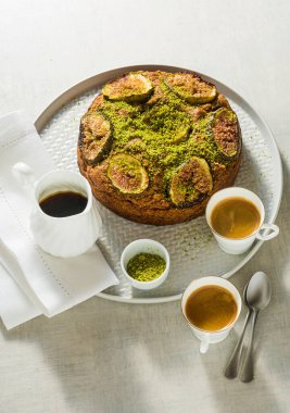 İncirli turta ve fındıklı kahve fincanları ve akçaağaç şurubuyla dolu bir masada. Sabah kahvaltısı ya da yaz kahvaltısı