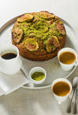İncirli turta ve fındıklı kahve fincanları ve akçaağaç şurubuyla dolu bir masada. Sabah kahvaltısı ya da yaz kahvaltısı