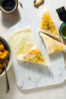 Baharatlı patates ve sebzeyle yapılan Hint samosasının adım adım tarifi. 