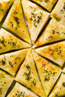 Baharatlı patates ve sebzeli Hint samosası. Fırında siyah susam tohumlarıyla pişirilmeye hazır.